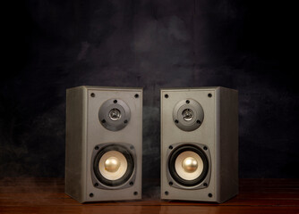 Two audio speakers with smoke in dark background room