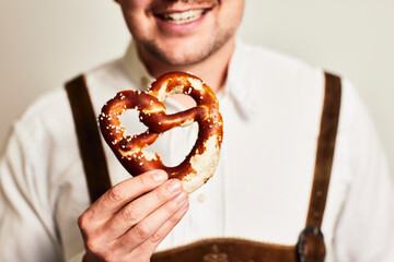 Wall Mural - Mann in Oktoberfest Tracht und Brezel