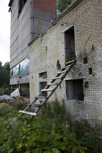 Wooden Staircase To The Second Floor Of A Destroyed Industrial Brick Building. A Picture Of Desolation And Destruction. Nature Destroys Buildings