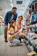 © Drazen - Happy family buying school supplies in supermarket.