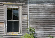 © David Halgrimson - a broken window on the wall of on hold schoolhouse with weathered siding
