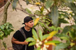 © PhotoFL - Estudiante con ropa negra deportiva sonriente entre las hojas