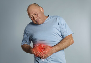 mature man suffering from liver pain on light grey background