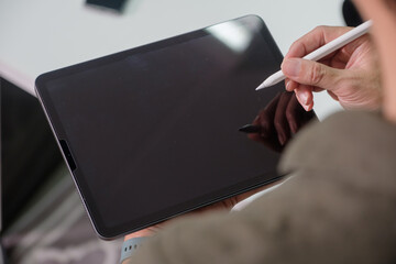 Close-up of a young businessman working on wear suit touch tablet pen.architect design in the office