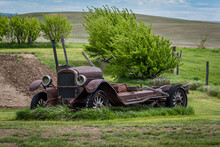 The Shell Of An Abandoned Vintage Car With Wooden Spokes In A Garden On The Saskatchewan Prairies