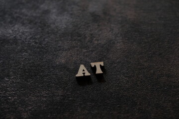 Wall Mural - The letters A and T above the dark field. Initials AT