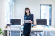 © 大 李 - A businesswoman in an office with a black shirt and skirt