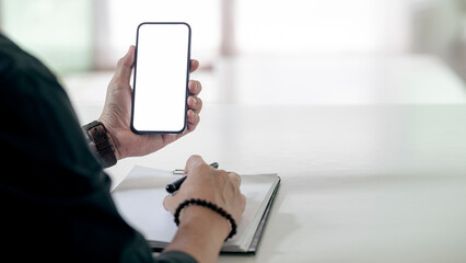 Wall Mural - mockup image blank white screen cell phone. man hand holding using mobile rat office. background emp