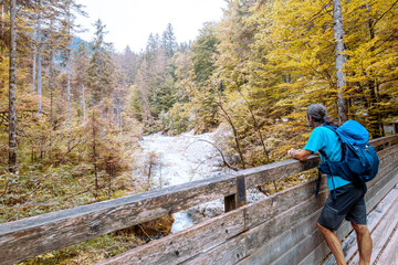 Wall Mural - Man standing at the Bridge, hiking in forest in the Wimbachtal in Germany. Enjoying the silent. 