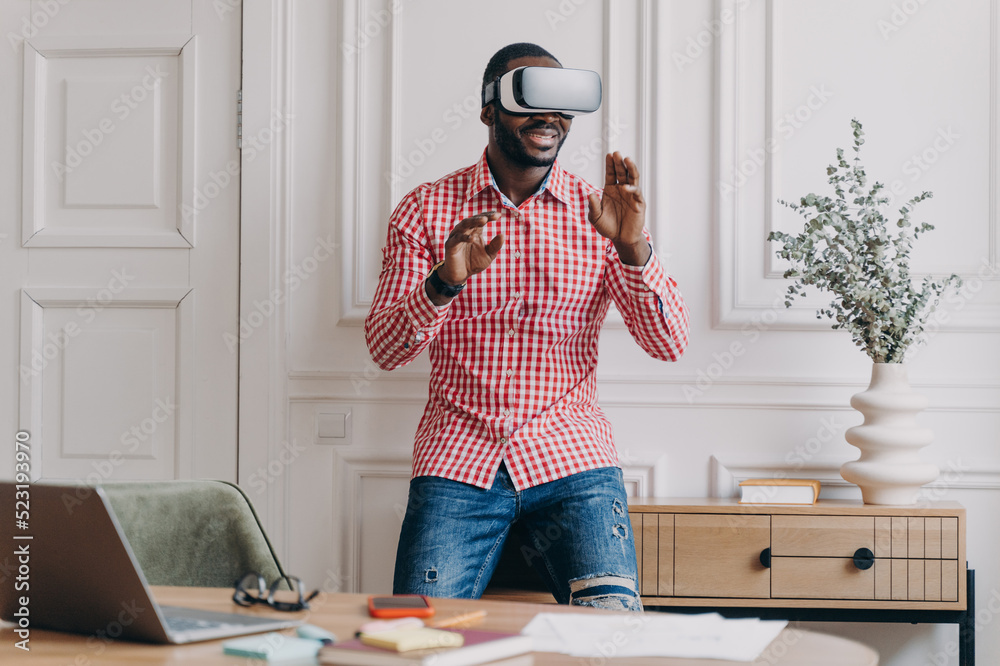 African man in VR headset interacting with digital interface, using ...