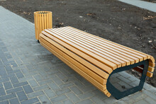 A Modern Comfortable Wooden Bench Without A Back And A Garbage Can Made Of Wooden Slats In A New Residential Area. Landscaping Of The House Territory