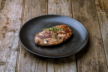 Poster - Grilled chicken Breasts on black plate on old wooden table