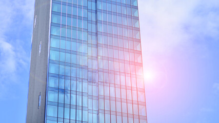  Modern glass facade against blue sky. Bottom view of a  building in the business district. Low angle view of the glass facade of an office building.