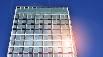 Modern glass facade against blue sky. Bottom view of a  building in the business district. Low angle view of the glass facade of an office building.