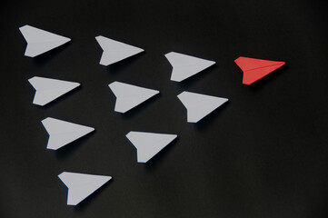 Wall Mural - red paper plane origami leading white planes on dark background. leadership skills concept