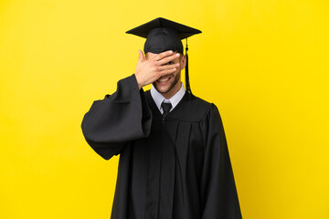 Wall Mural - Young university graduate caucasian man isolated on yellow background covering eyes by hands and smiling