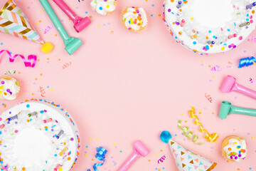 Wall Mural - Birthday party frame on a soft pink background. Top view with cakes, party hats and confetti. Copy space.