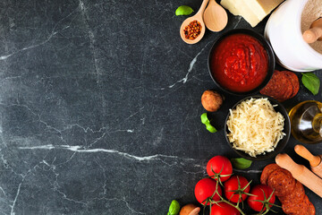 Canvas Print - Pizza making ingredients including cheese, pepperoni, tomatoes and basil. Top view side border against a dark background. Copy space.