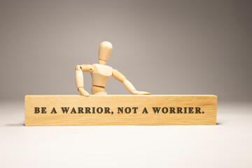 Be a warrior, not a worrier written on wooden surface. Motivation and personal development.