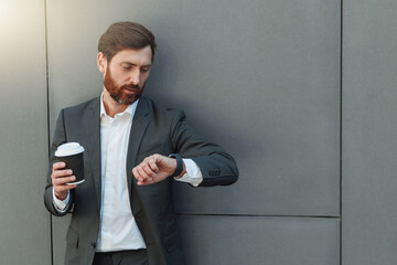 Sticker - Focused european businessman in suit with coffee watching on his wrist watch during break