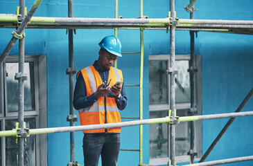 Poster - Male construction worker working checking a digital building plan on a phone. Busy urban development builder looking at buildings planning data to give industry information on a two way radio
