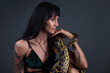 Photo of the brunette woman in profile sitting with yellow anaconda