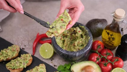 Wall Mural - woman making bruschetta with freshly made guacamole sauce at domestic kitchen