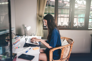 Young adult asian student woman stay at home using laptop computer and study online