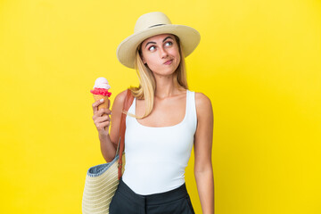 Wall Mural - Blonde Uruguayan girl in summertime holding ice cream isolated on yellow background and looking up