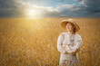 Rural woman  standing in a golden wheat field.