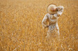 Rural woman  standing in a golden wheat field.