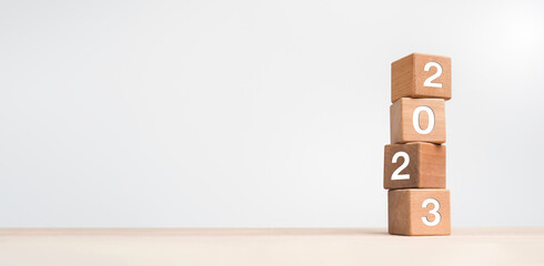 Poster - 2023 Happy New year background banner. Two thousand Twenty-Three year numbers on wooden cube blocks stack on white background with copy space. Welcome, Merry Christmas, and Happy New Year in 2023.