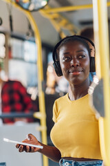 Poster - African american woman riding a bus and using a smartphone