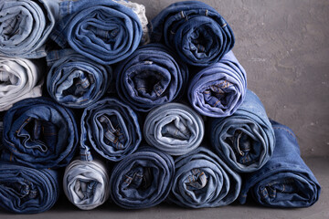 Wall Mural - Blue jeans denim heap on table background. Jeans fabric heap as material surface