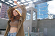 Cool teen stylish redhead fashion hipster girl model posing in big city urban location. Beautiful teenage generation z girl with red hair wearing trench coat looking at camera. Portrait