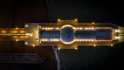 Wall Mural - Aerial view of Brighton pier at night with all the colours coming out, East Sussex, UK