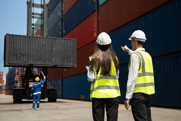 Wall Mural - Caucasian two businessman and businesswoman working in container site.  Attractive engineer people discussion orders and product at warehouse logistic in cargo freight ship for import export in harbor