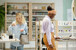 © pressmaster - Two young intercultural female shoppers choosing skincare products in cosmetic supermarket while standing in front of displays