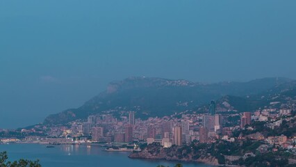 Wall Mural - Cityscape of Monte Carlo night to day transition panoramic timelapse, Monaco before summer sunrise. Morning mist. Yachts on harbor. Top view from Cap Martin