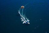 Fototapeta Nowy Jork - Drag Boat parasailing top view. The boat pulls a parachute with people.