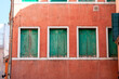 red facade with three weathered green window