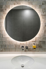 Wall Mural - white washbasin, water faucet and round mirror on wall in bathroom