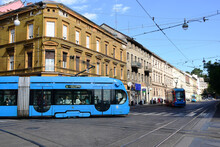 Modern Blue Tram Side Perspective View In Zagreb, Croatia. Major Street In Downtown. Old Classic Residential Buildings And Stucco Facades In The Background. Travel And Tourism Concept. Urban Scene.