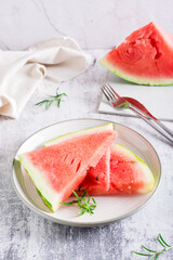 Pieces of fresh juicy watermelon on a plate on the table. Summer refreshment. Vertical view