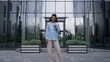 © stockbusters - Pleased businesswoman posing drinking coffee cup on contemporary office facade.