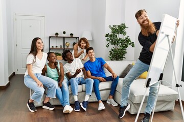 Wall Mural - Group of young friends smiling happy playing drawing game at home.