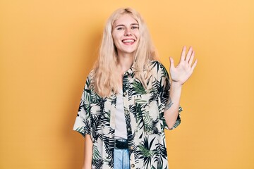 Sticker - Beautiful caucasian woman with blond hair wearing tropical shirt showing and pointing up with fingers number five while smiling confident and happy.