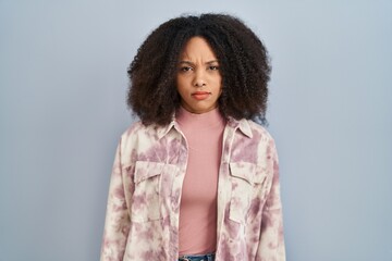 Poster - Young african american woman standing over blue background skeptic and nervous, frowning upset because of problem. negative person.