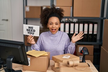 Poster - Young african american woman working at small business ecommerce holding banner celebrating victory with happy smile and winner expression with raised hands