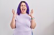 © Krakenimages.com - Plus size woman wit purple hair standing over isolated background celebrating mad and crazy for success with arms raised and closed eyes screaming excited. winner concept